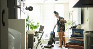 young woman vacuuming her