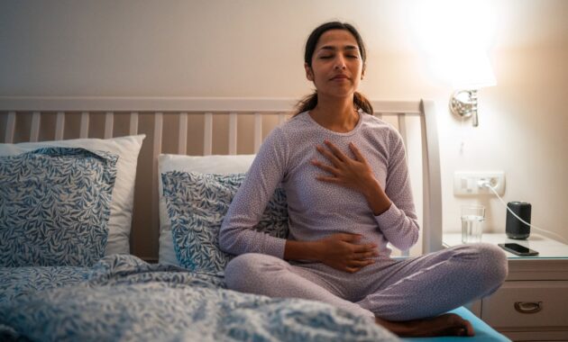 Indian Female Practicing Relaxation Before Sleep in Bedroom 2184439853 1257x838