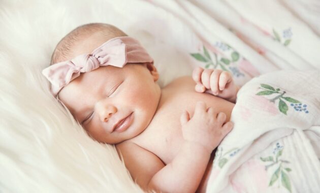 Sleeping newborn baby in a wrap on white blanket. 853843646 2125x1417 scaled 1