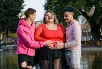 plus size pregnant woman with friends hands on belly