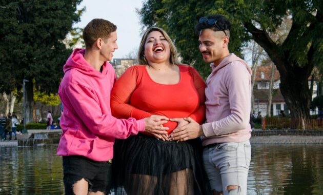 plus size pregnant woman with friends hands on belly