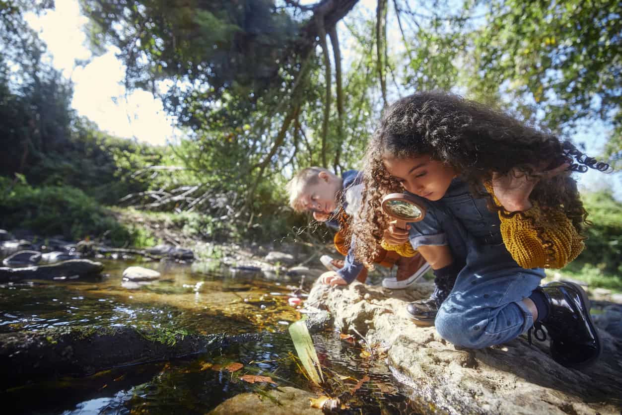 Small boy and girl looking at river with magnifier 1287882633 1257x838.jpeg