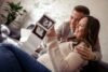 expecting couple holding up ultrasound scaled.jpg