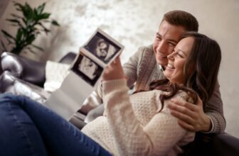 expecting couple holding up ultrasound scaled.jpg